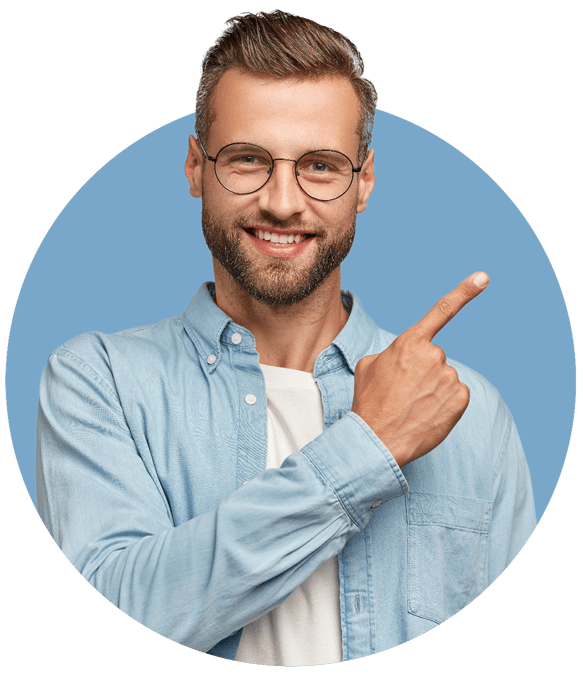 A smiling man wearing glasses and a denim shirt points to the right.