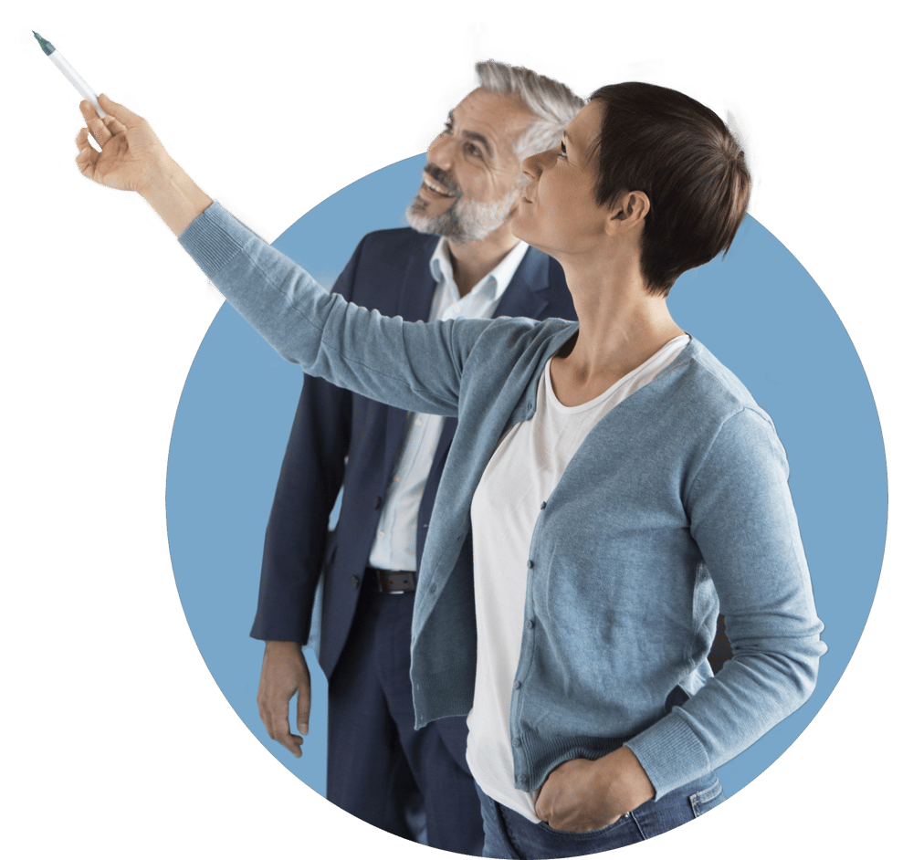 A woman points up and to the right while a man stands behind her and looks in the same direction.